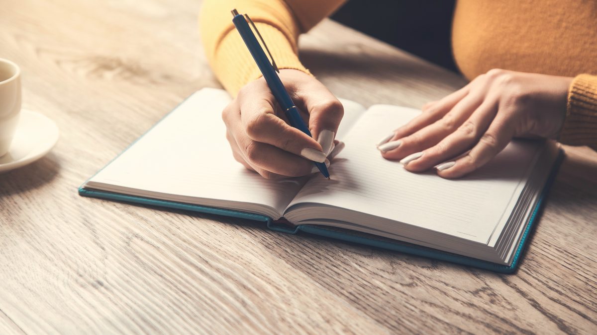 Mains qui écrivent sur un cahier lors d'une révision